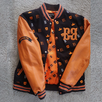 Varsity jacket with brown, orange, and white design on a gray surface | FBB M3 VARSITY One‑of‑One Collector’s Edition