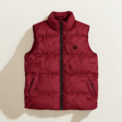 A sleeveless quilted down puffer vest in deep burgundy red, featuring a high stand-up collar, a front zipper closure, and a black embroidered monogram logo on the left chest, displayed flat against a light beige background.