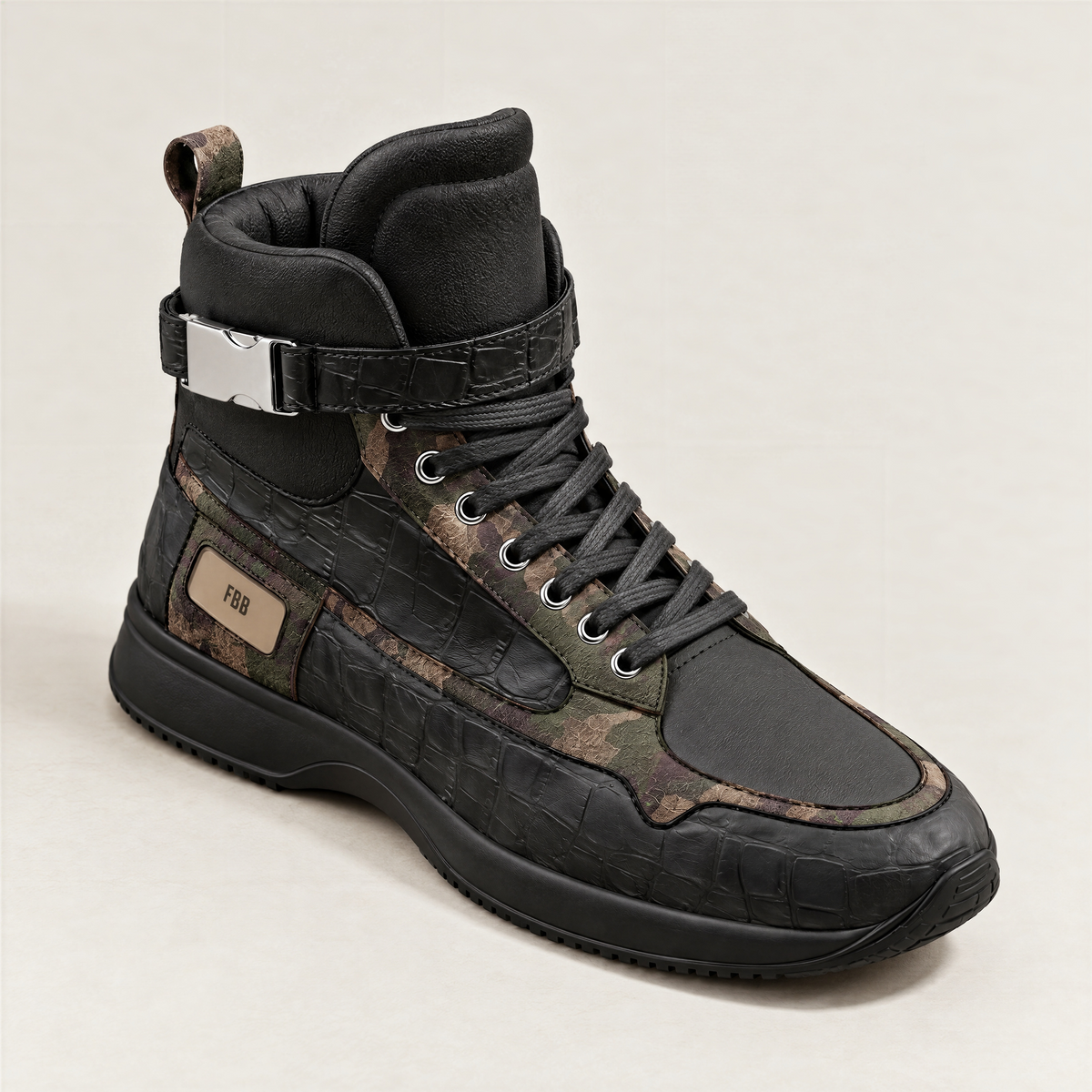 A single high-top sneaker in black textured italian leather and italian suede with camouflage panels, a silver buckle strap, and a tan 'FBB' label on the side, photographed against a light off-white background.