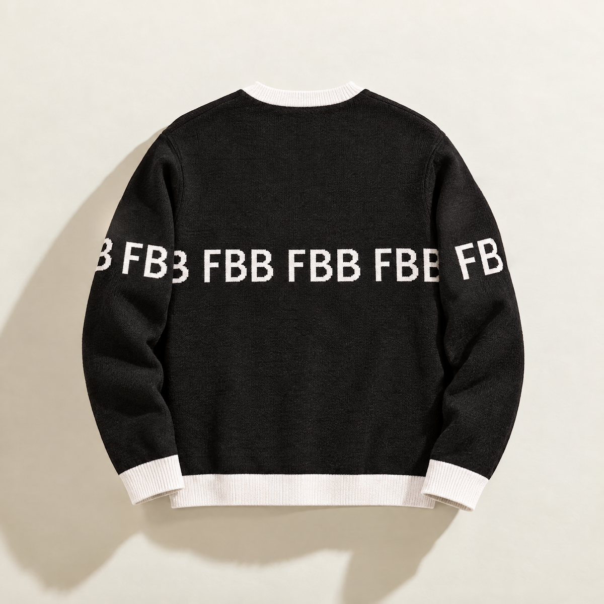 Back of FBB Legacy Black knit sweater with white trim and repeating white FBB lettering across the back and sleeves.
