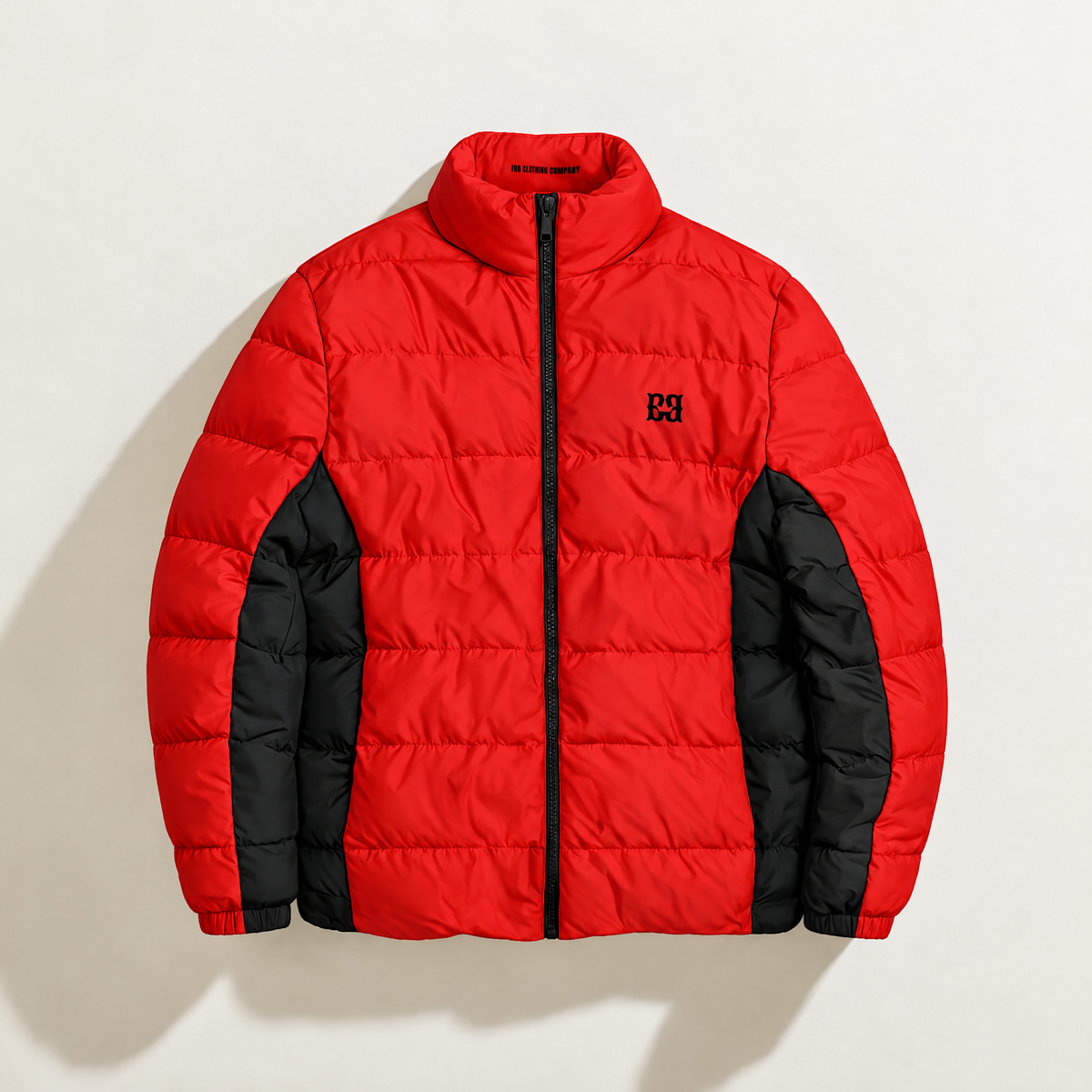 Front view of the red FBB puffer jacket with black side panels, a black zipper and chest