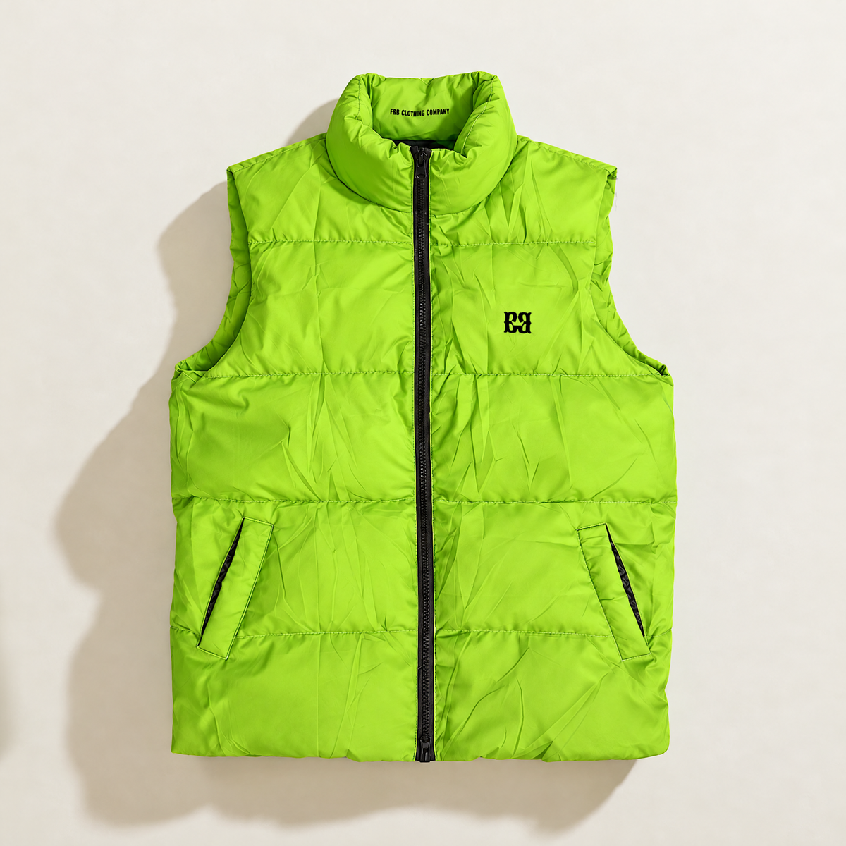 A lime green sleeveless down puffer vest with a high collar, black front zipper, and a black the FBB Clothing company logo on the left chest, displayed flat against a light beige background.