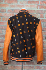 Varsity jacket with brown, orange, and white design on a gray surface | FBB M3 VARSITY One‑of‑One Collector’s Edition